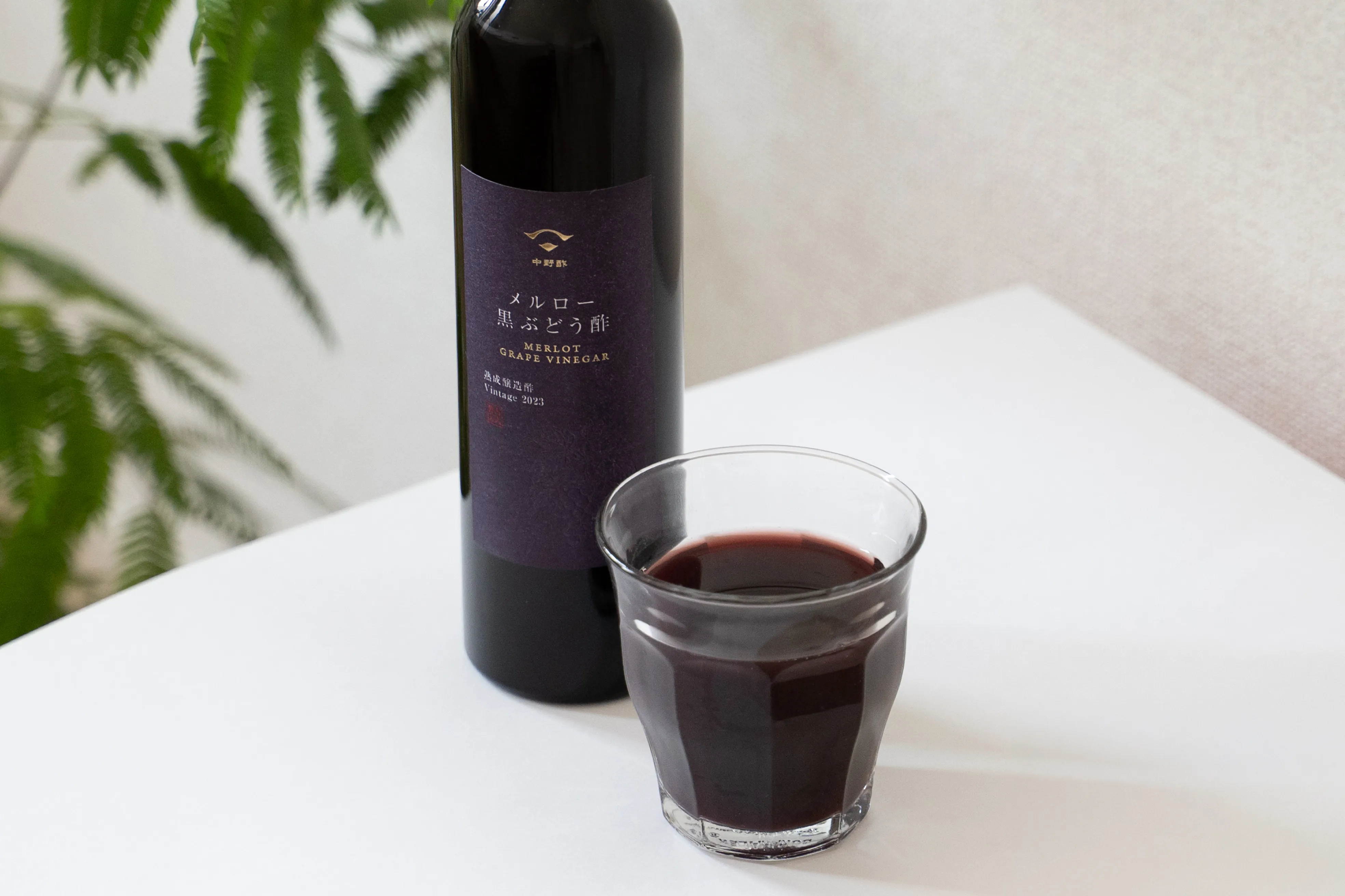 金の箔押しを使った黒ぶどう酢ラベルと商品を並べた写真