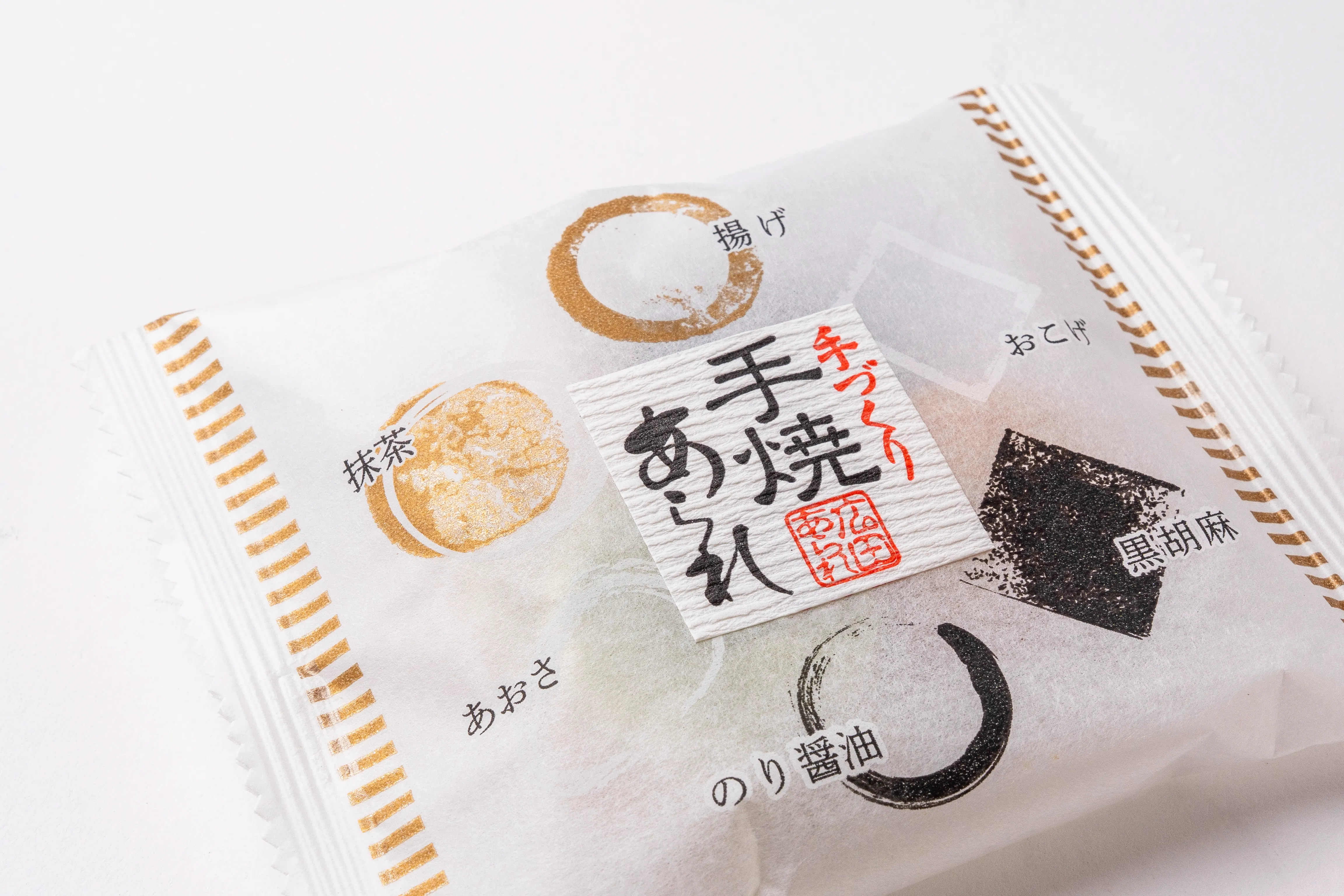 和紙クレープの横方向の凹凸と黒・特色赤の印刷が見えるあられシールの拡大